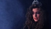 Annie Blackburn wearing the Miss Twin Peaks crown in a dark smokey space