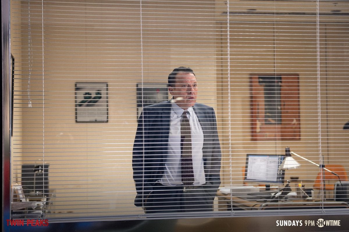 Anthony Sinclair looks through his office blinds and panics