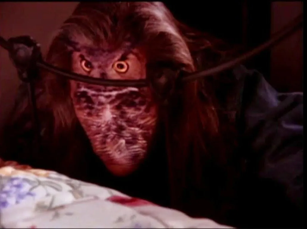 Bobs face replaced with an owl as he crouches at the foot of Laura's bed