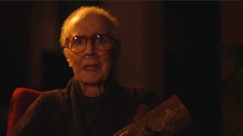 the Log Lady with breathing tube holds her log