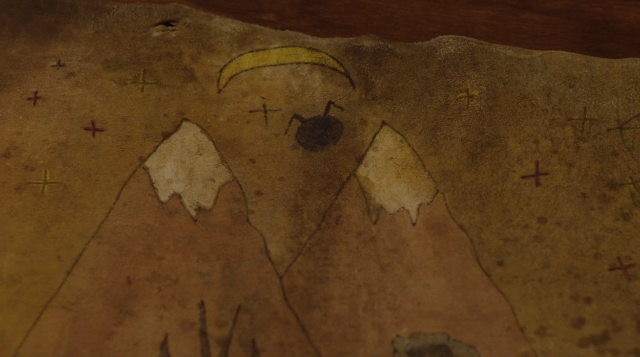 the two mountain peaks, a crescent moon and the mother or owl shape above the mountains shown on the living map