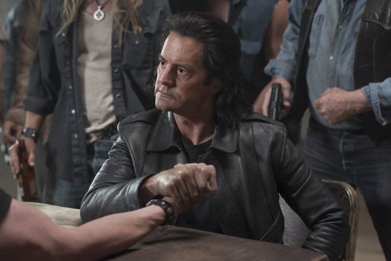 Mr C arm wrestles a man at a table