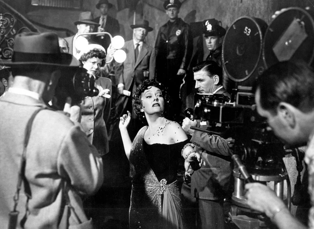 Norma Desmond ready for her closeup, surrounded by photographers and police