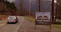 car driving by the welcome to twin peaks sign