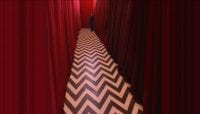 a chevron floored corridor with red curtains