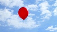 a red balloon floating in the sky