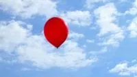 a red balloon floating in the sky