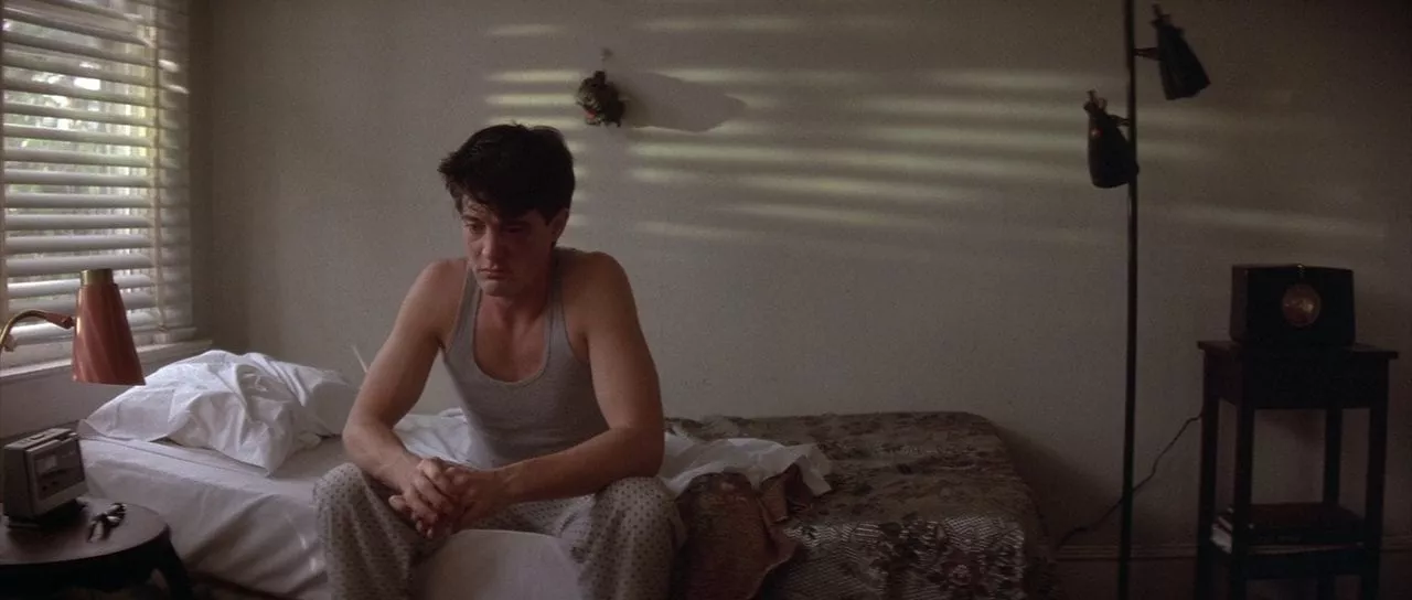 Jeffrey Beaumont sits on his bed slightly battered