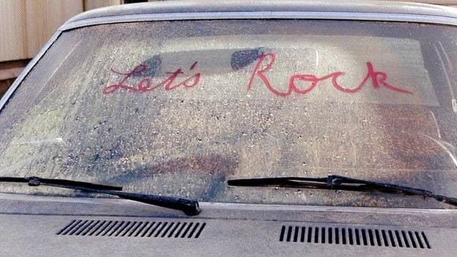 lets rock written in lipstick on a dirty car windscreen