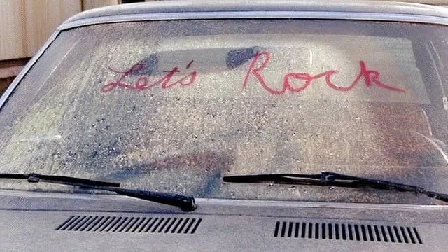lets rock written in lipstick on a dirty car windscreen