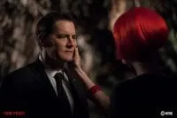 Diane with red hair caresses the face of Dale Cooper