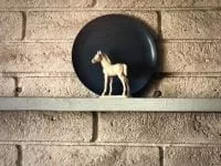 white horse figurine in front of a blue plate
