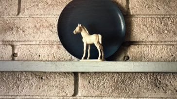white horse figurine in front of a blue plate
