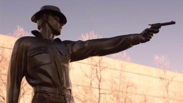 a statue of a cowboy raising his gun