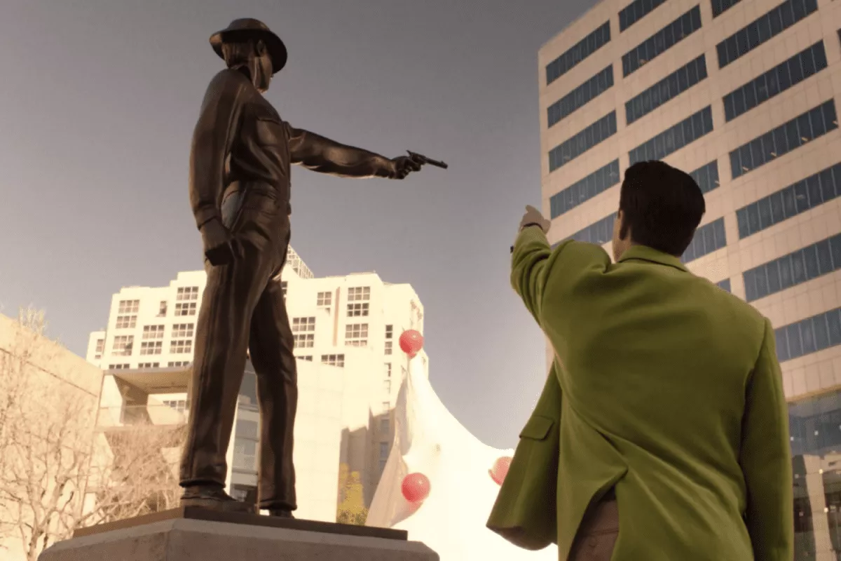 Dougie Jones mimics the bronze statue of a cowboy shooting his gun