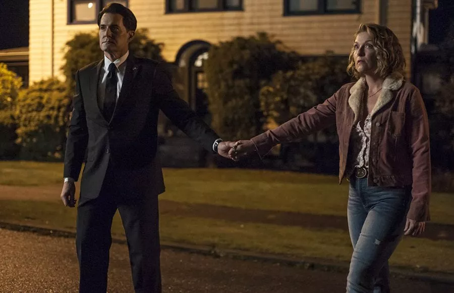 Cooper and Carrie hold hands outside the Palmer house