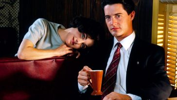 audrey horne rests her head on dale coopers shoulder while he drinks coffee in a booth