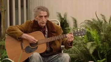 Carl Rodd plays acoustic guitar