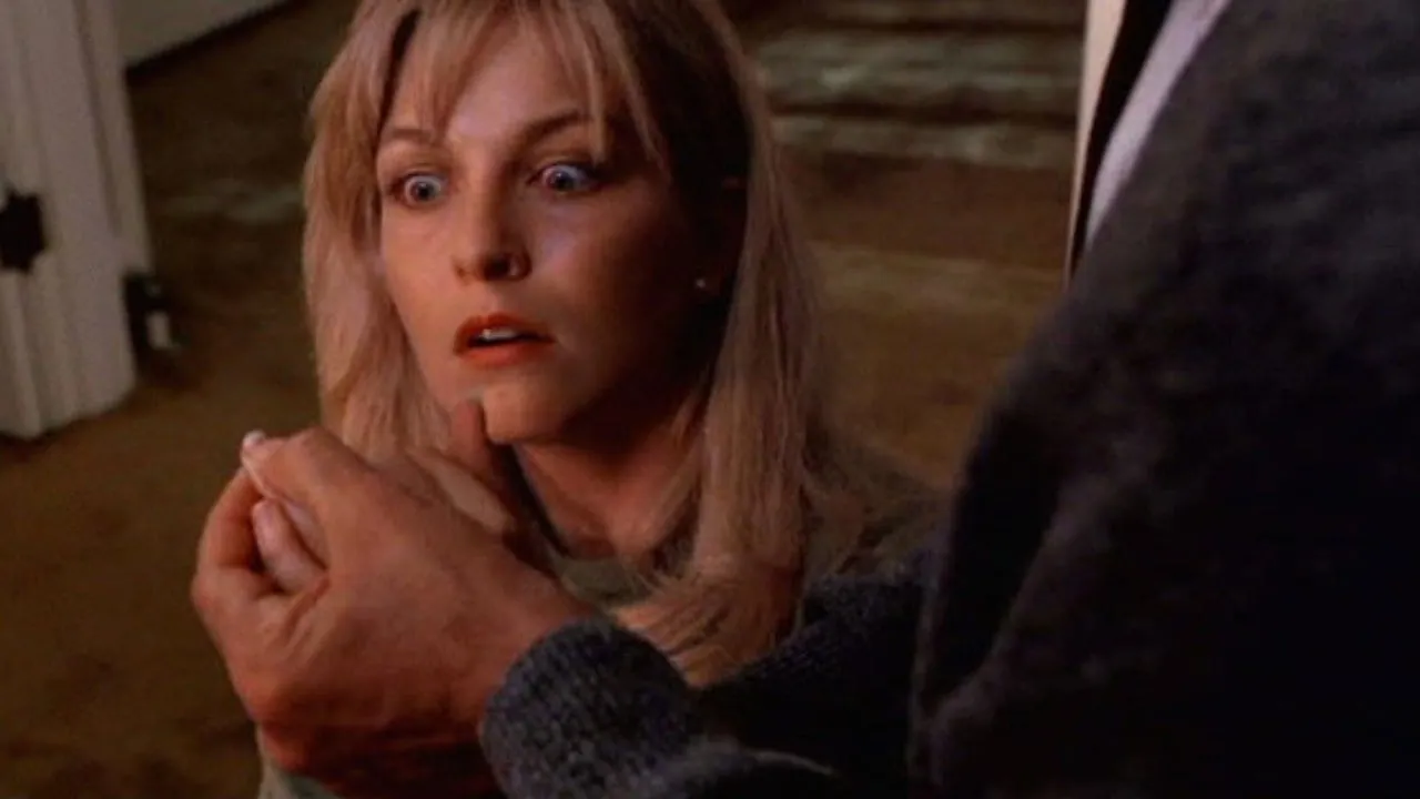 Laura Palmer looks frightened as her father checks her fingernails for dirt