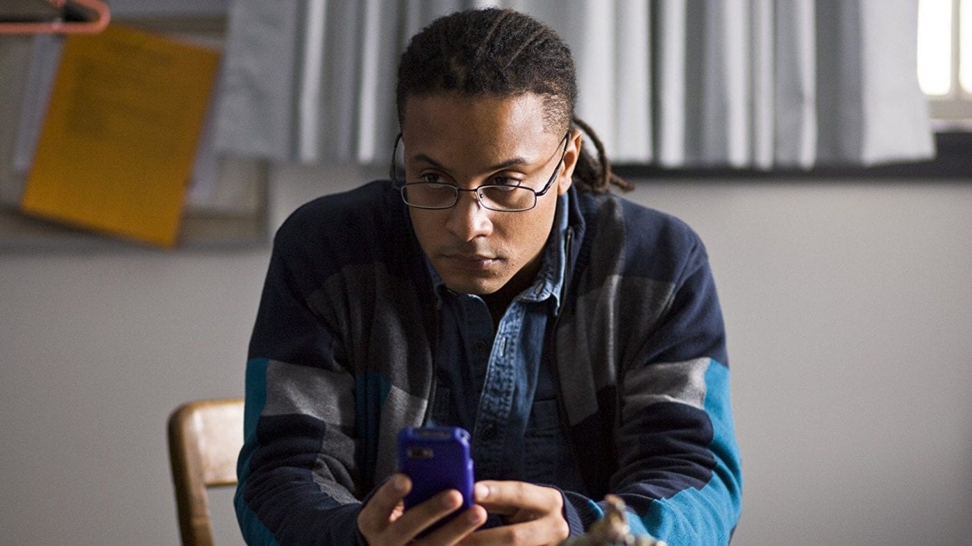 Brandon Jay McLaren as Bennet Ahmed texting on his phone in The Killing