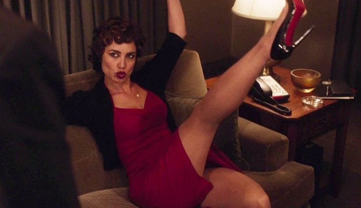 The French woman pouts and kicks one leg into the air