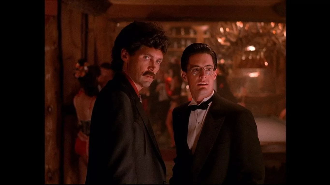 Big Ed wears a curly wig and moustache, Agent Cooper wears a Tuxedo