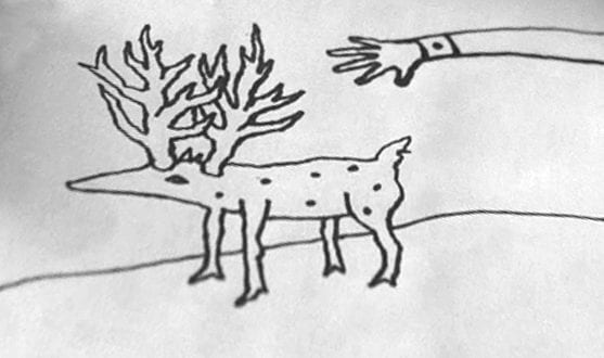 A hand reaches toward a doglike creature with antlers