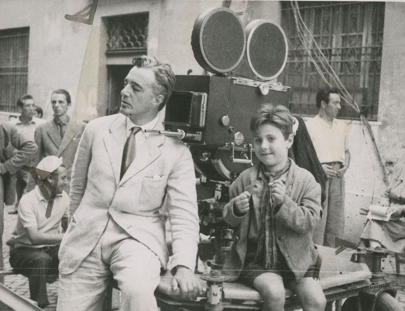 a man and a boy sit by a film camera in Bicycle Thieves