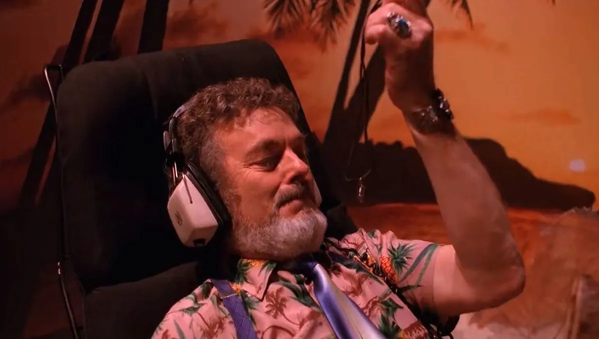 Jacoby in his office with earphones, holding a coconut