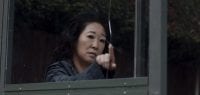 Eve Polastri (Sandra Oh) from Killing Eve contemplates a crack in a bus shelter before smashing the glass