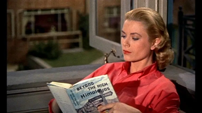 Kelly pretends to read Beyond the Himalayas to impress her man, in Rear Window