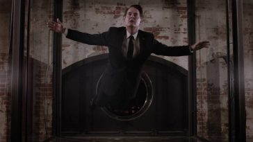 Dale Cooper floats inside a glass box in a sparse room with brick walls in New York.