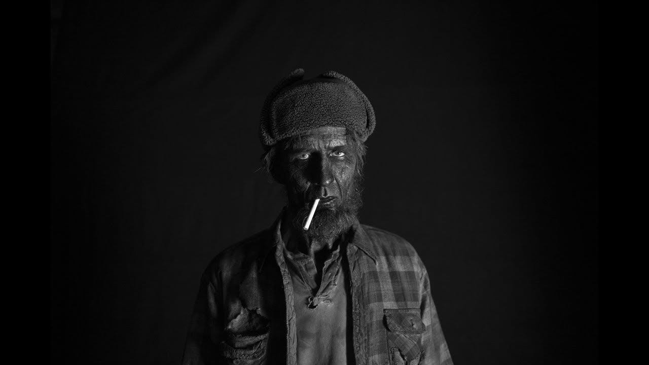 the woodsman, black from head to toe and with a cigarette in his mouth