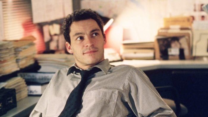 Jimmy McNulty sits in his office wearing a tie and striped shirt in The Wire's pilot episode