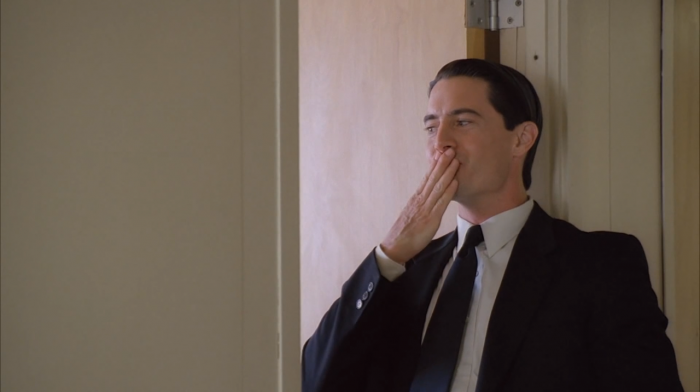 Dale Cooper blows a kiss into the apparent office in which Diane is in