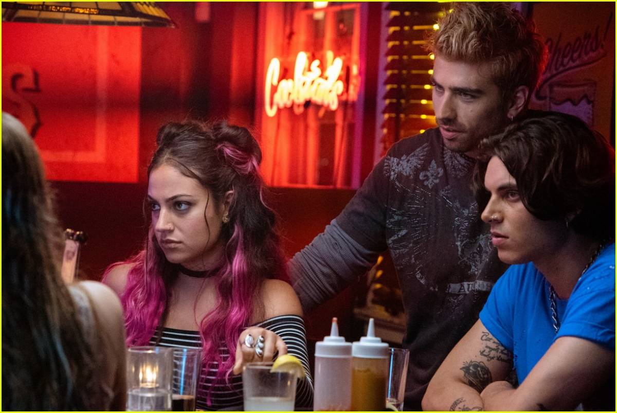 Tessa's roommates, a girl with purple hair and 2 lads sit at a table in a bar