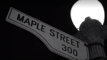 A Maple Street sign is attached to a lamp post