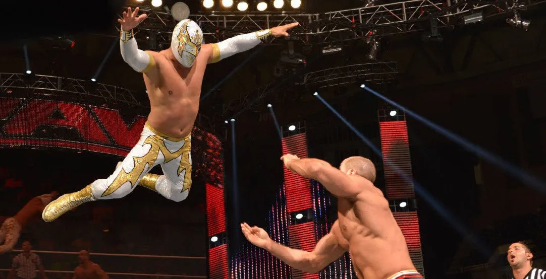 Rey Mysterio Jr leaps off the top turnbuckle onto Cesaro