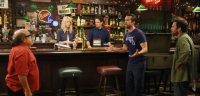 Dennis, Dee, and Charlie stand in Paddy's Pub watching Mac yell at Frank