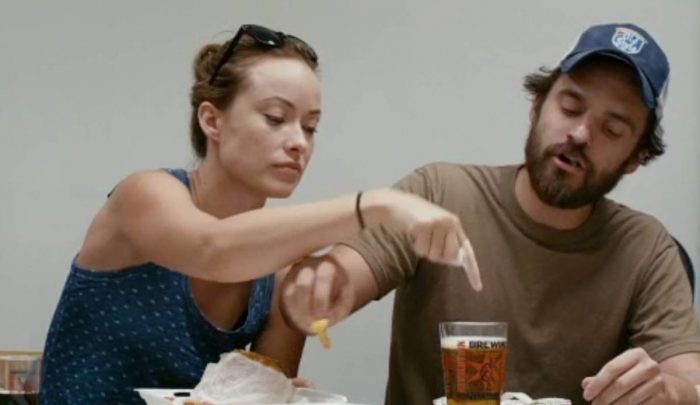 Kate (Olivia Wilde) pokes a finger in her best friend Luke's (Jake Johnson) beer while he steals a bite of her lunch.