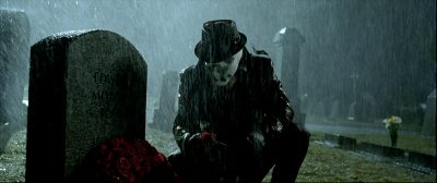 Rorschach kneels in front of a gravestone