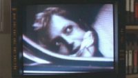 a security screen shows a close-up image of a gagged Dana Scully in the trunk of a car.