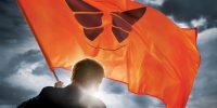 Promo photo, an over-the-shoulder shot of David holding an orange flag with a butterfly on it
