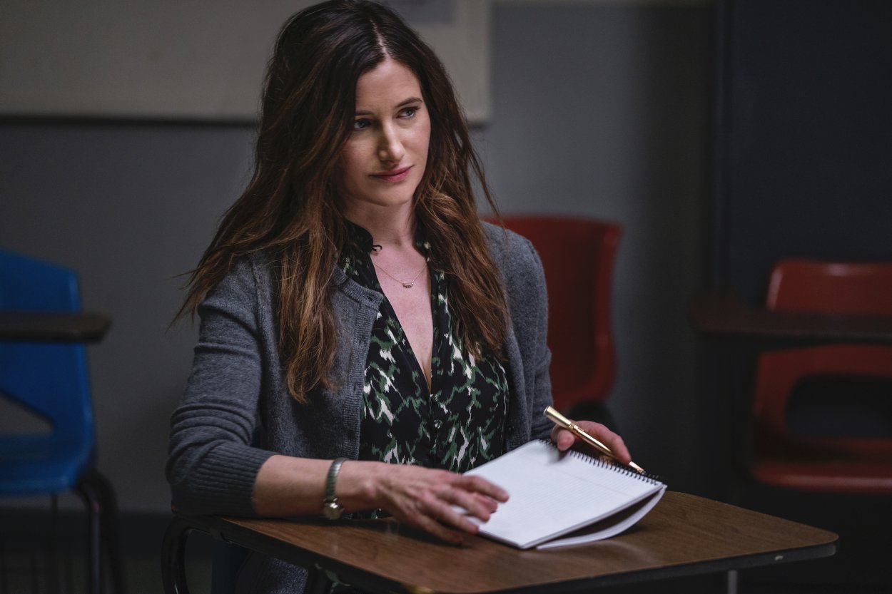 Eve sits at a desk with a notebook open in her personal essay class