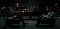 Will and Hannibal sit in chairs opposite each other in Dr. Lecter's office