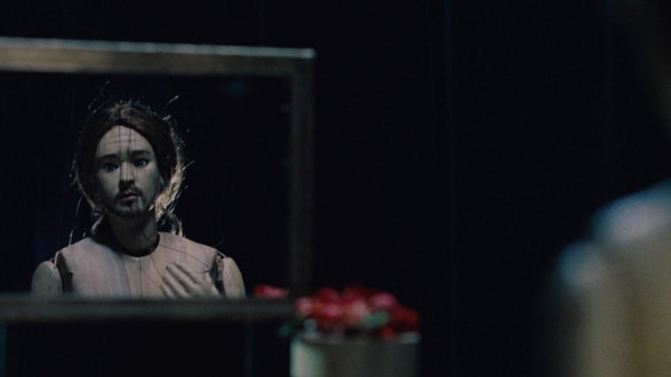 The puppet of Craig looks sadly at himself in a mirror