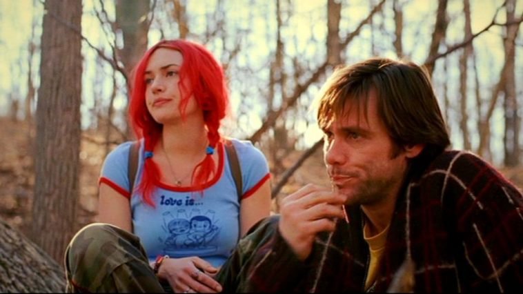 Clementine and Joel sit outside in a wooded area looking glum