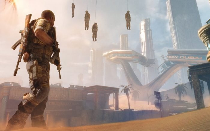 Captain Walker stands on the sand ridden streets of Dubai while buried skyscrapers and hanging corpses loom in the background.