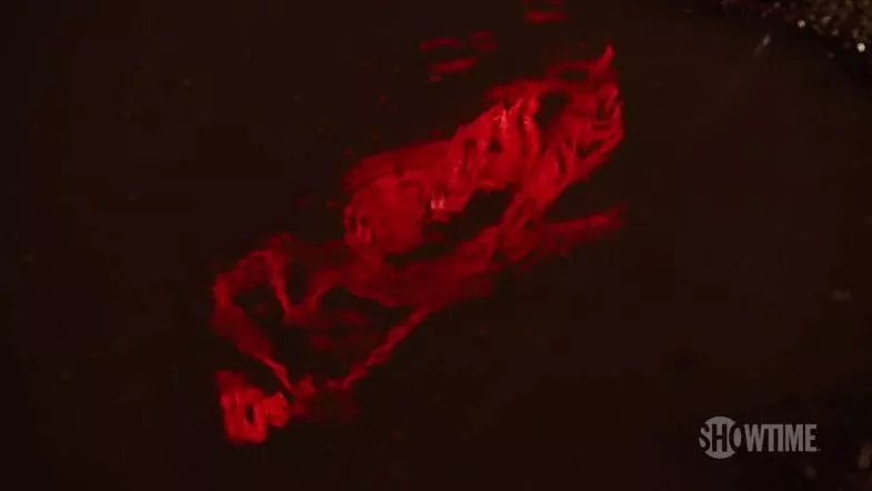 The rippled reflection of the bang bang bar sign in a parking lot puddle, close up.