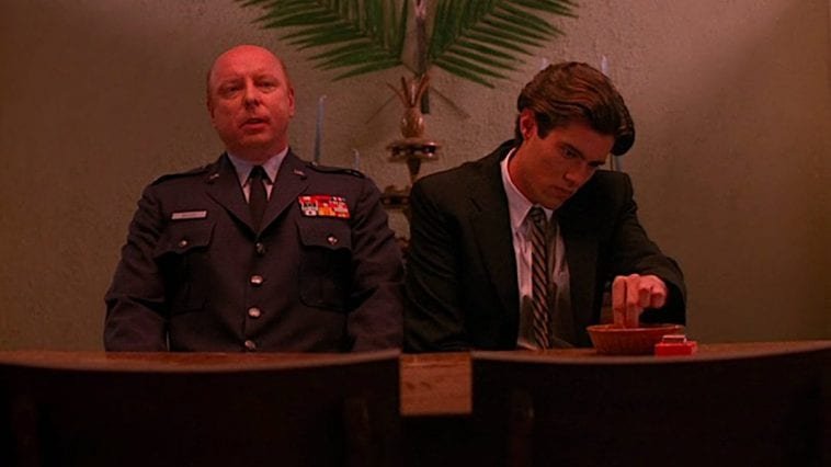 Bobby and the Major sit next to each other in the Birggs house before Laura's funeral